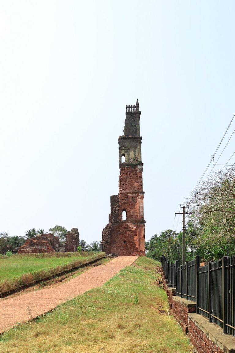An old, tall brick tower stands near a path.